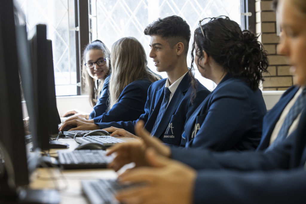 A photo of Leigh Academy Mascalls students sitting together and working on computers.