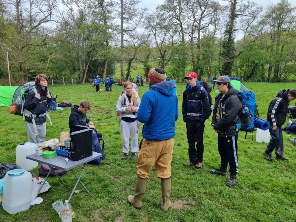 DofE Students in a field with camping gear on