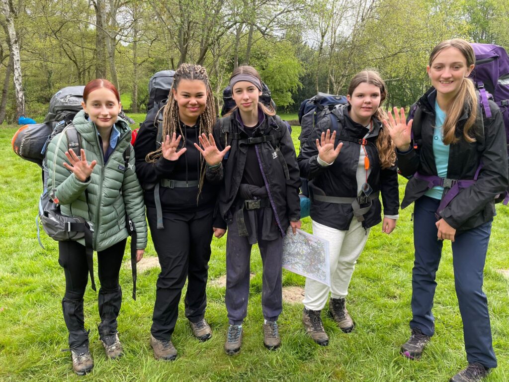 DofE Students in a field with camping gear on